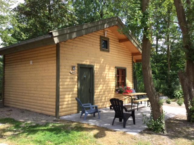 维灵厄韦夫Hollands Oostenrijks huisje的小屋前面设有桌椅的小棚子