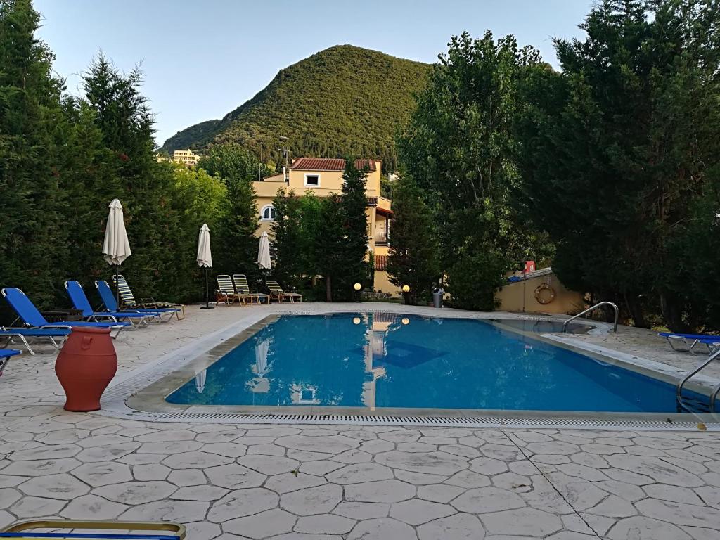 埃尔莫奈斯Villa Litsa的一个带椅子的游泳池,后方是一座山。