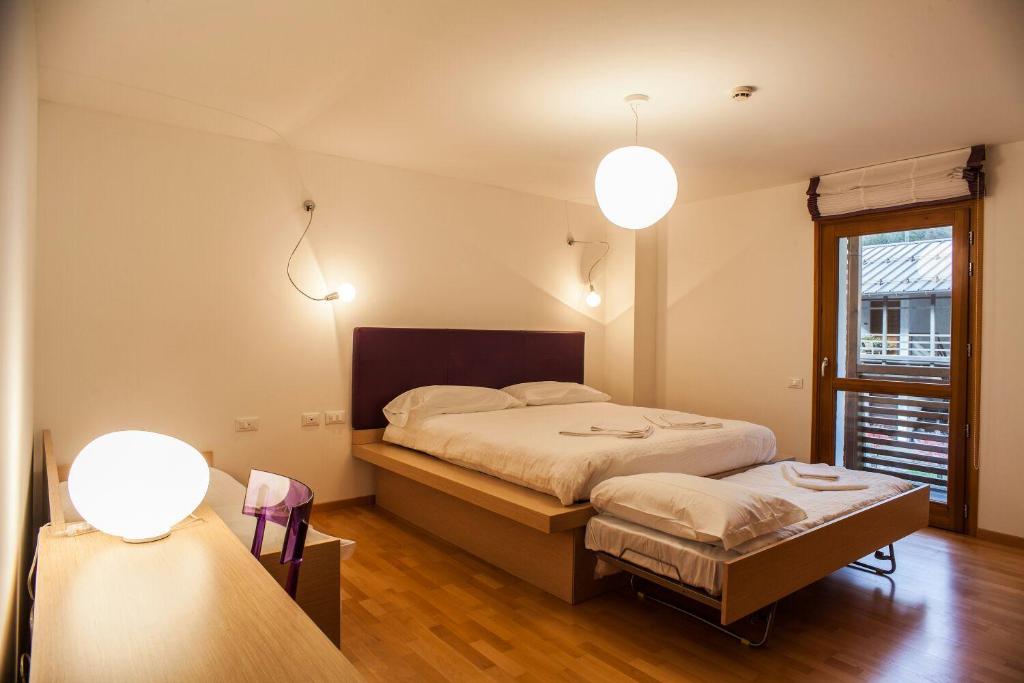 Forni di SottoHotel Pramaggiore的一间卧室配有床、窗户和2盏灯