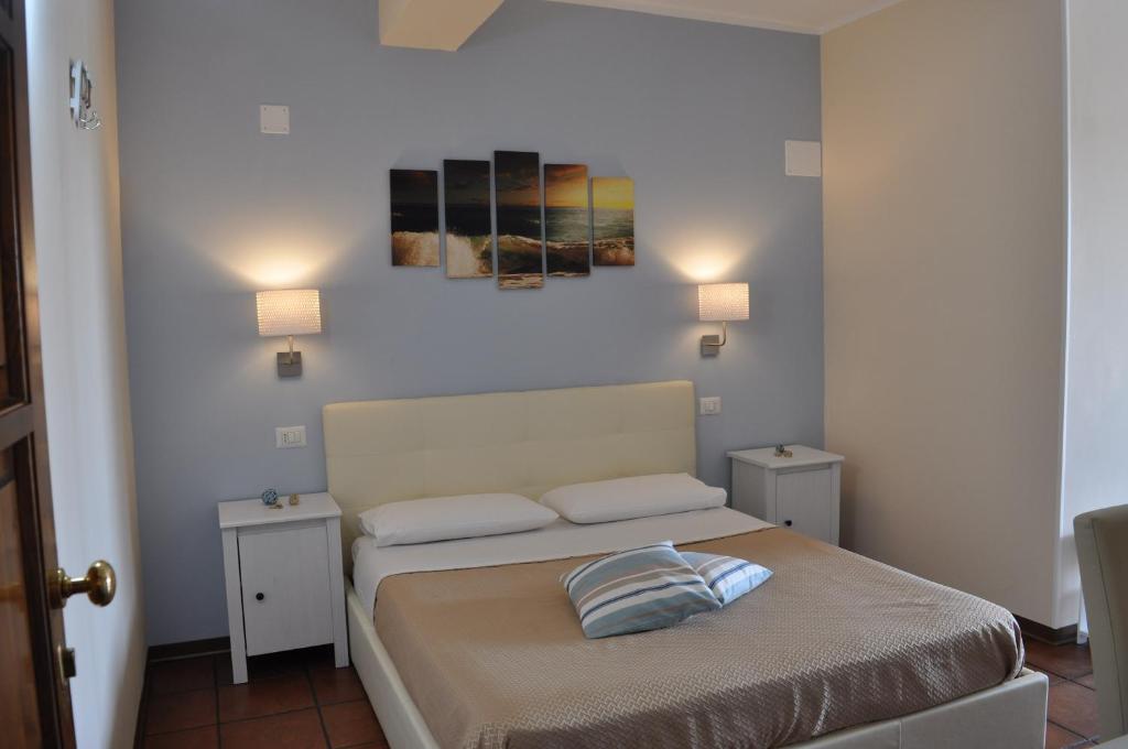 特罗佩阿Il Palombaro Rooms的一间卧室配有一张带两张桌子和两盏灯的床。
