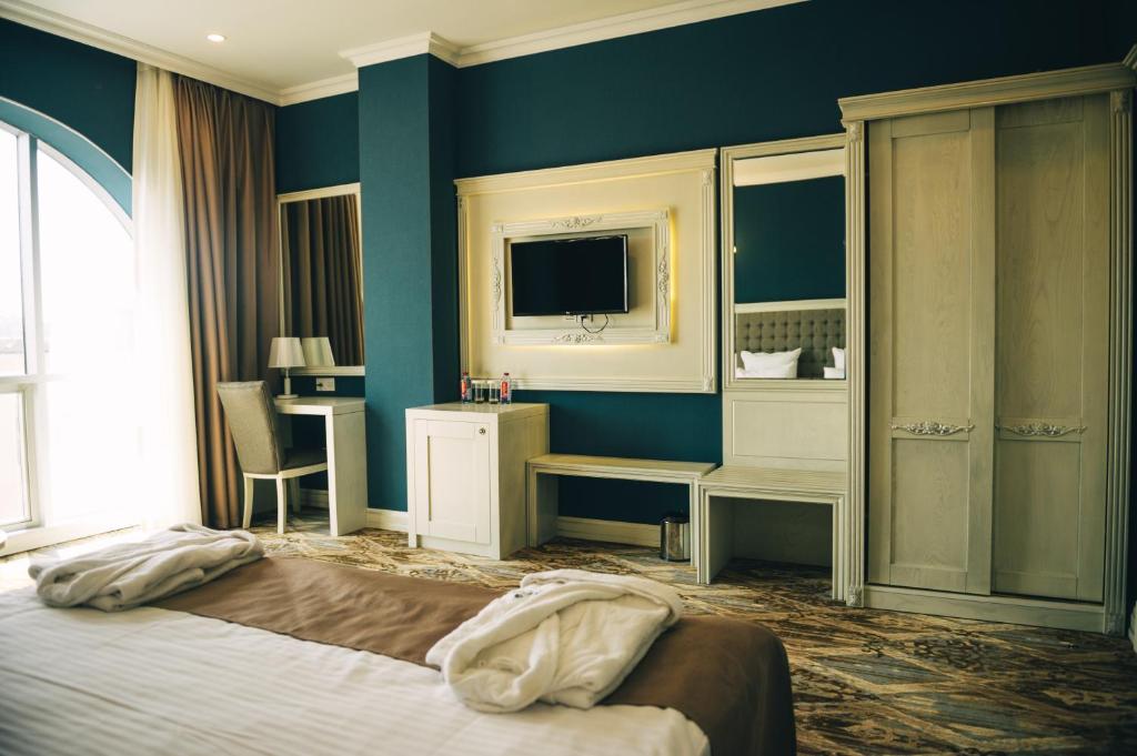 巴库Emerald Suite Hotel的酒店客房,配有床和电视