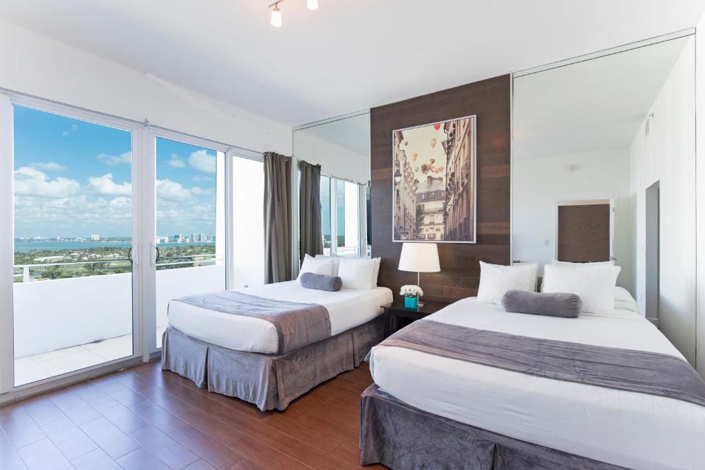 迈阿密海滩新起点迈阿密海滩公寓酒店的配有大窗户的酒店客房内的两张床