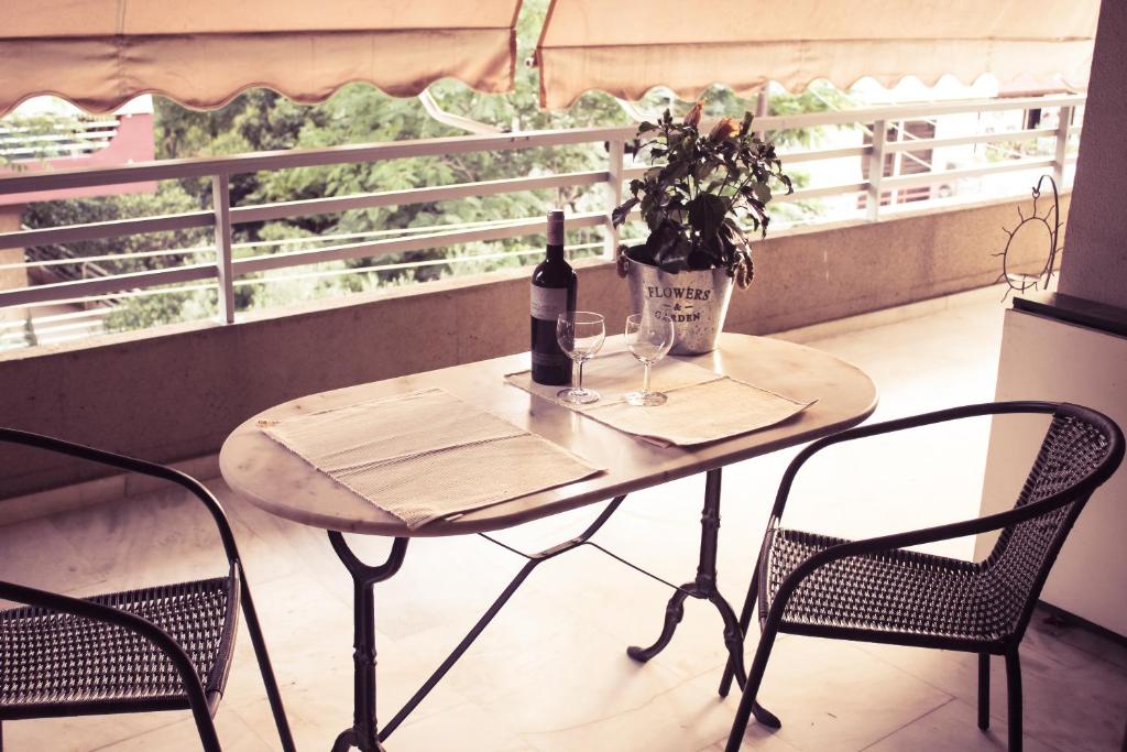 雅典City Break Nearby Metro And Bus Express Airport的一张桌子、一瓶葡萄酒和两把椅子