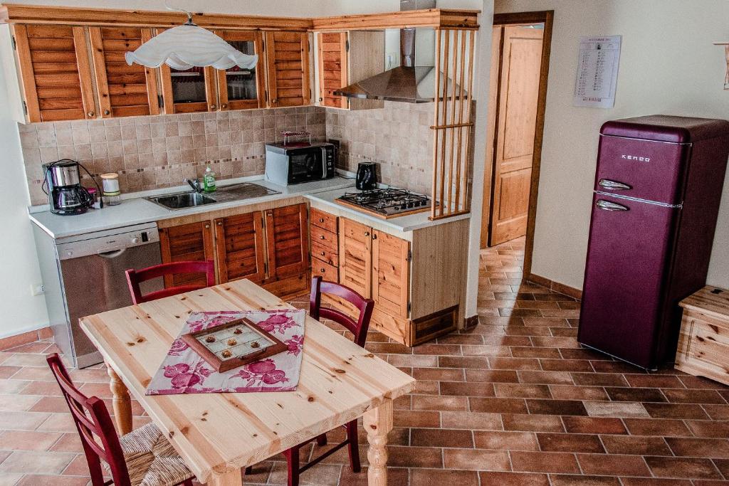 帕拉伊阿Casa Sirio的厨房配有木桌和紫色冰箱