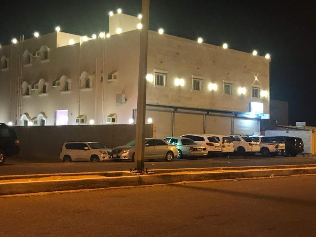 延布Etlalet Al-Sharm Apartments的夜间在大楼前的停车场