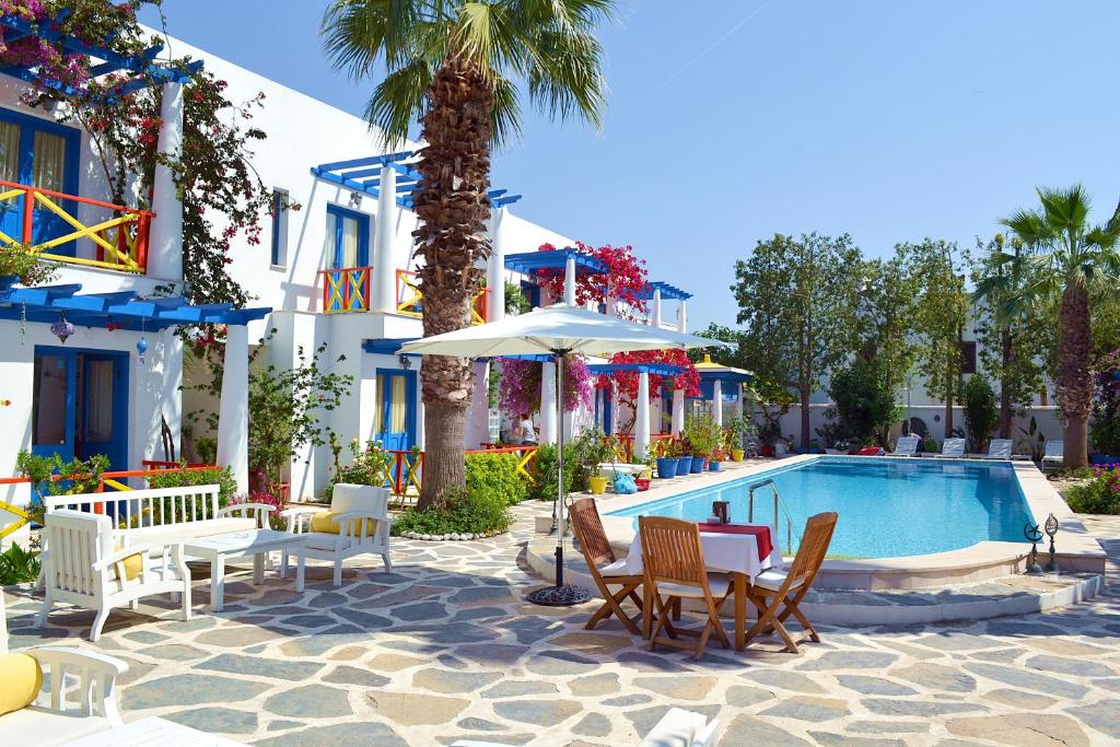 博德鲁姆Su Hotel - Bodrum的一个带游泳池、椅子和棕榈树的度假村