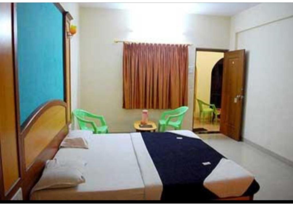 西姆拉Hotel Pankaj的一间卧室配有一张床和绿色椅子