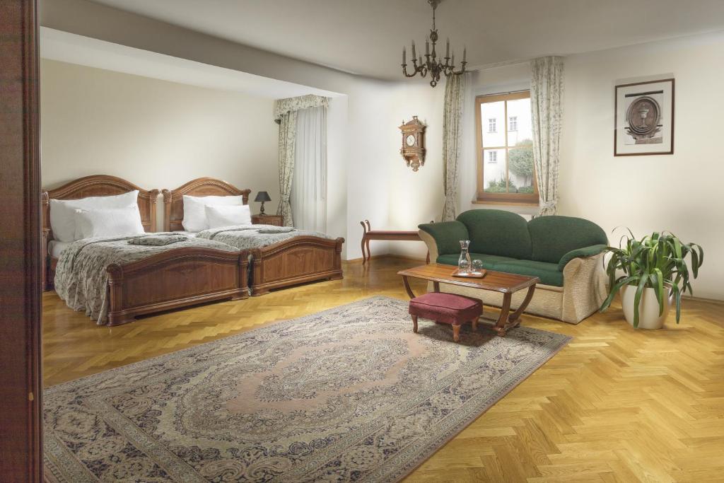 布拉格康斯坦斯精品酒店的一间卧室配有一张床、一张沙发和一张桌子