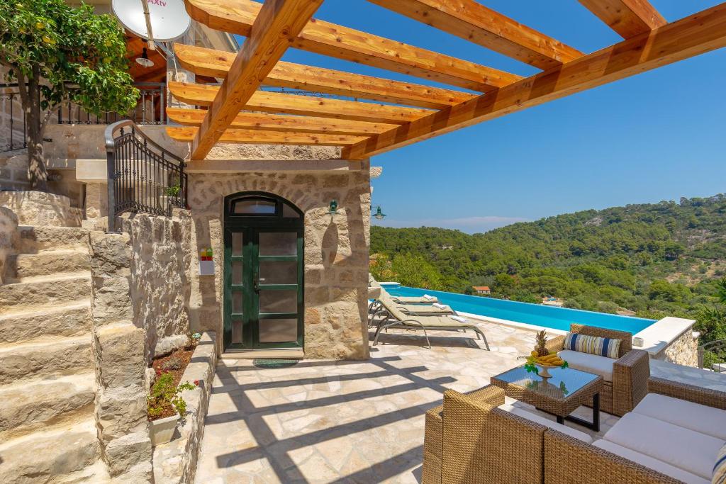 古维达里Villa Klacina的一个带木制凉亭和游泳池的庭院