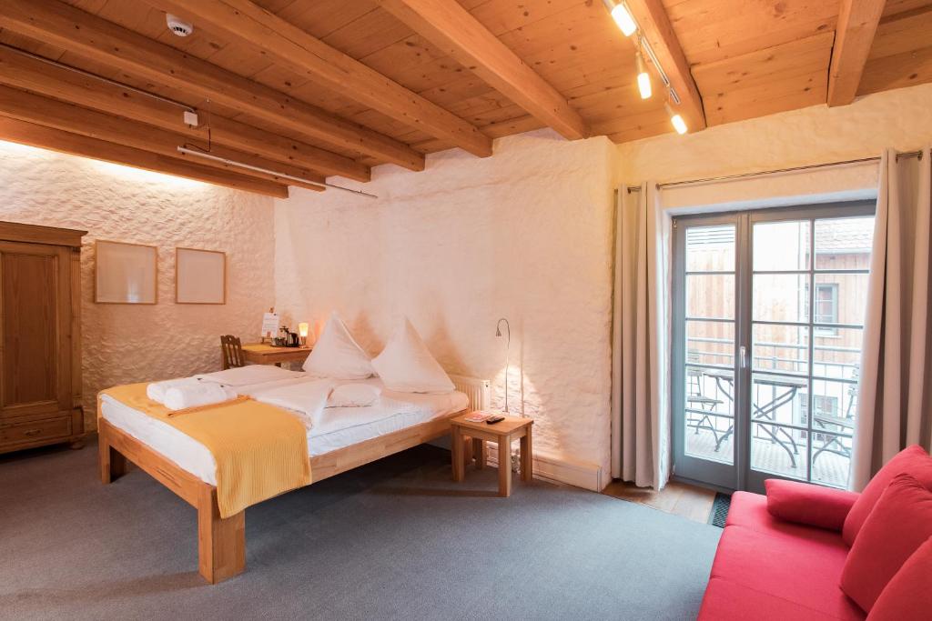 纽伦堡孔斯特卡缇尔比奥酒店的一间卧室配有一张床和一张红色的沙发