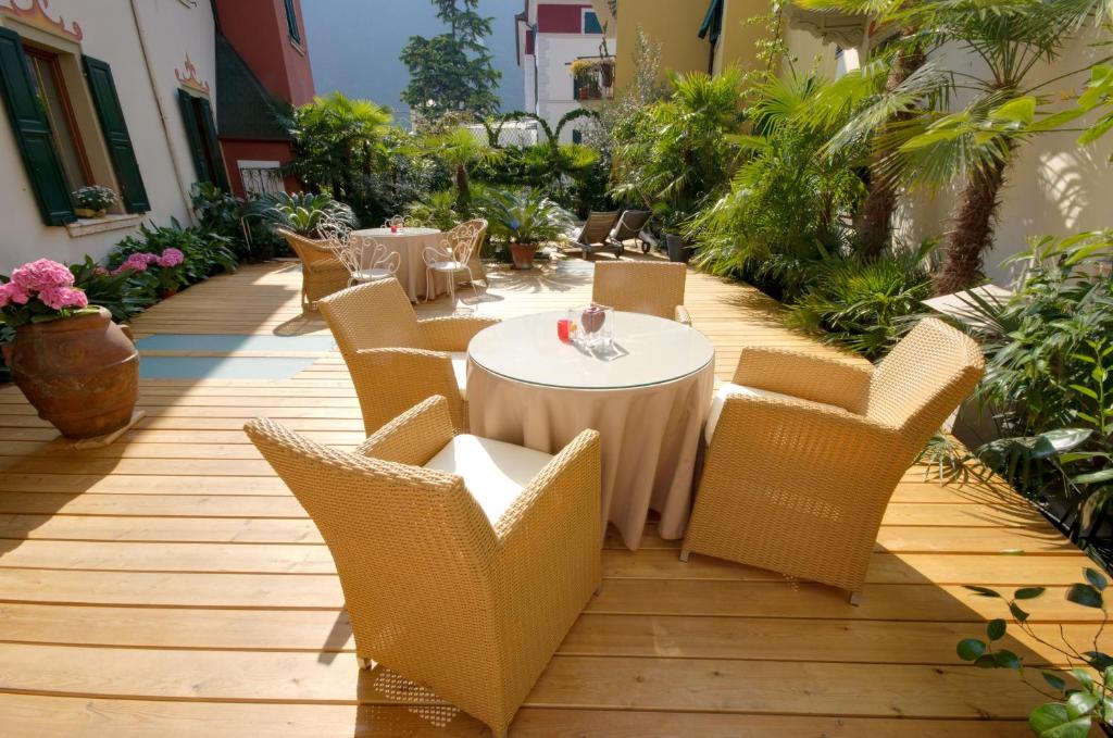加尔达湖滨Sembenini Palace的庭院配有桌椅和植物