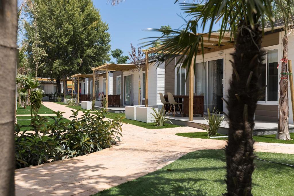 德尼亚洛拉诺斯露营&平房酒店的前方一排种有棕榈树的房屋