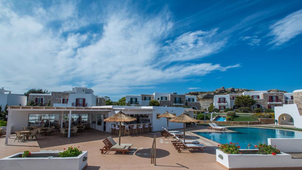 斯泰里达纳克索斯皇宫酒店的享有带游泳池和桌椅的度假村景致