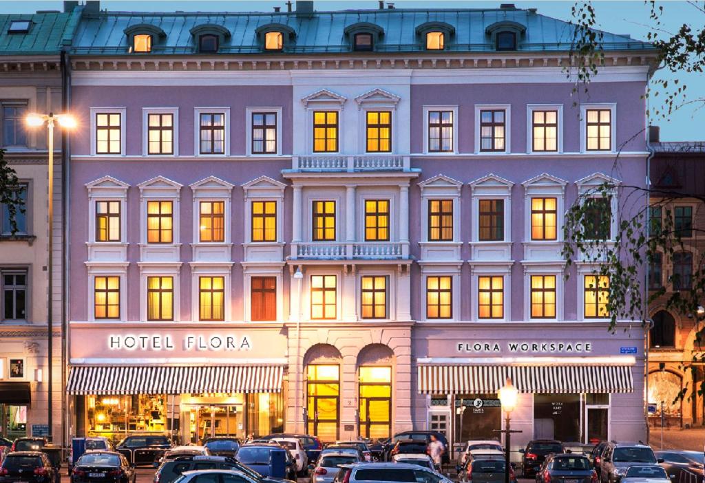 哥德堡弗洛拉酒店的一座大型建筑,前面有汽车停放