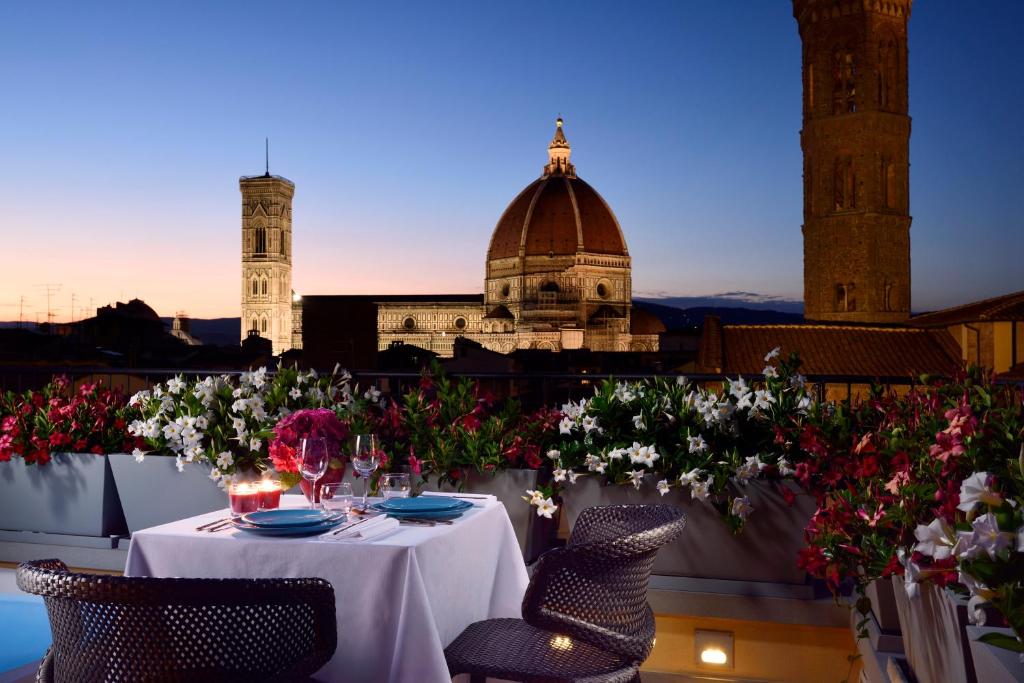 佛罗伦萨圣佛罗伦萨套房Spa酒店的鲜花阳台和建筑上的桌子