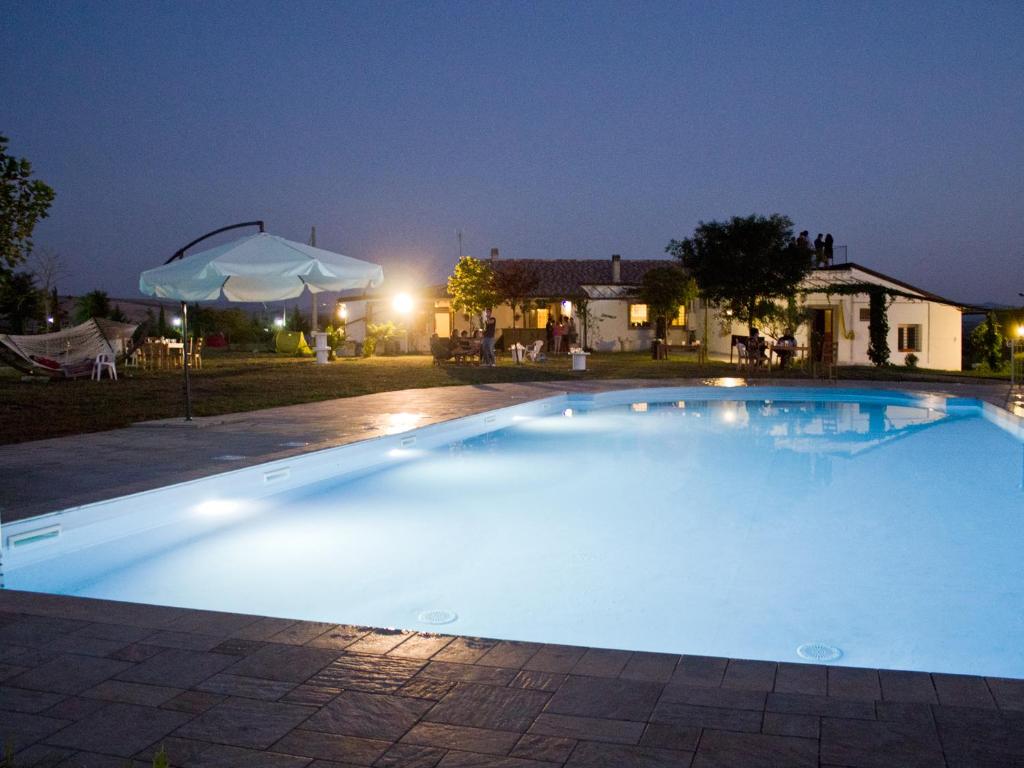 IrsinaVilla Lancellotti的夜间在院子里的大型游泳池