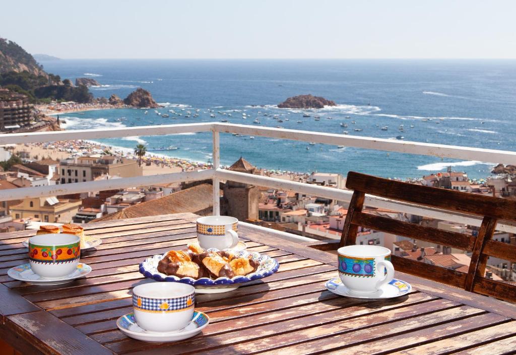 滨海托萨Lets Holidays Apartment Costa Brava的阳台上的桌子上放着咖啡和食物
