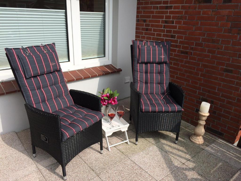 埃姆登„Lüttje Nüst“的庭院里设有两把椅子和一张桌子