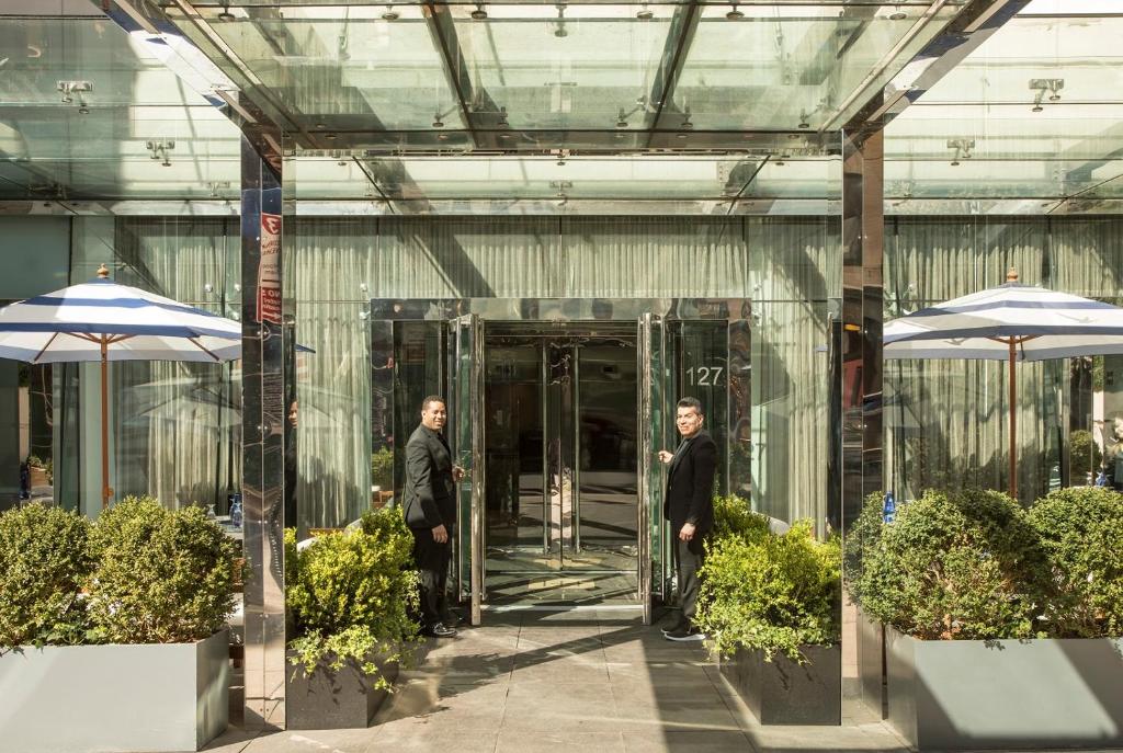 纽约纽约海登酒店的两个人步行进入一个带遮阳伞的玻璃建筑