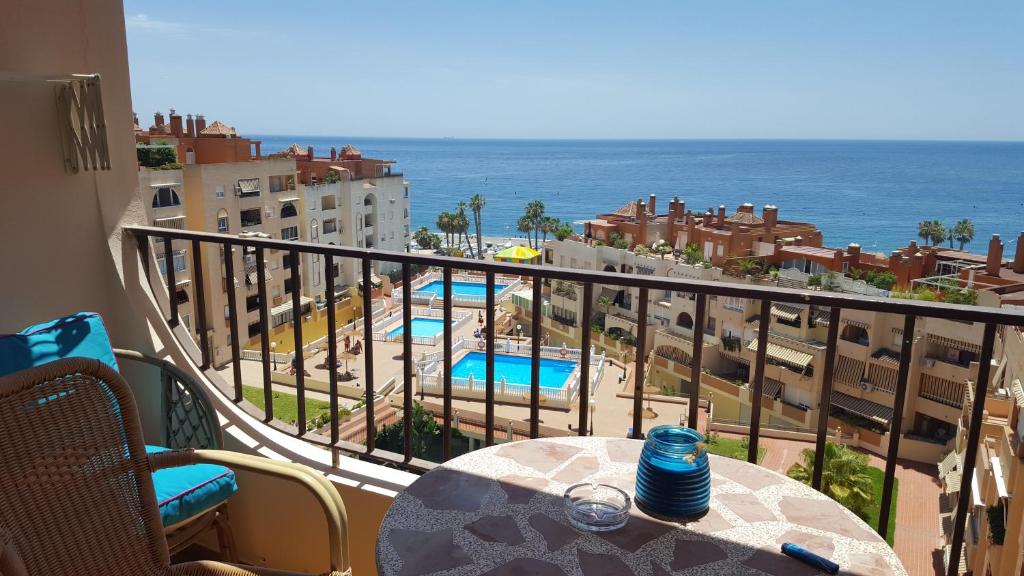 阿尔姆尼卡Apartamento con vistas en Mariote的阳台配有桌子,享有海景。