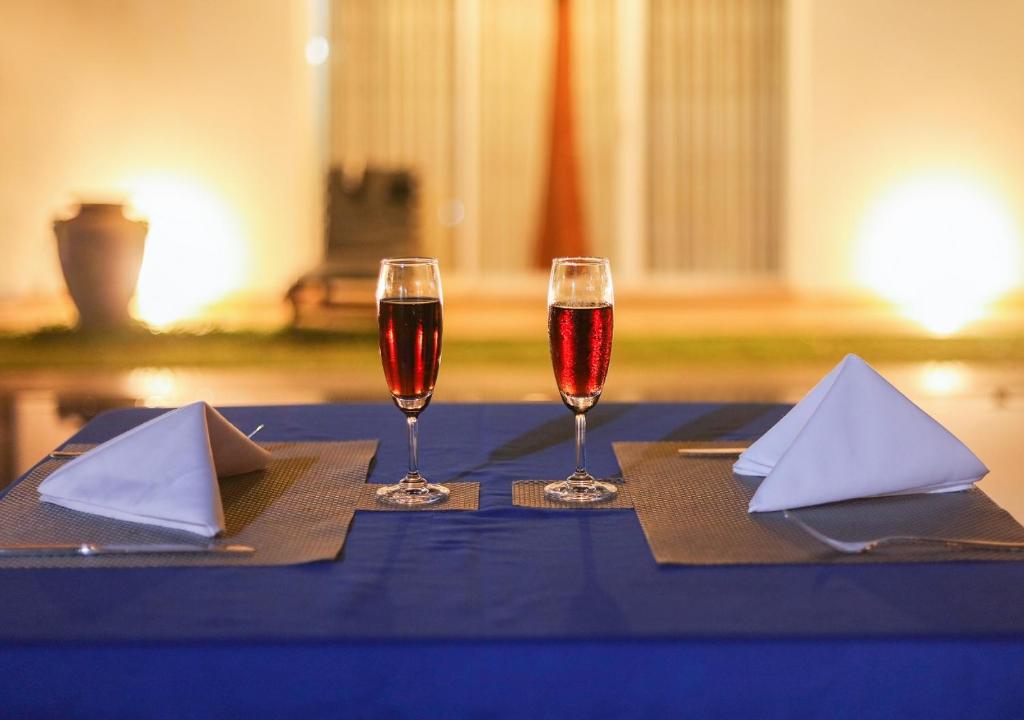 马拉维拉White Rose Beach Resort的两杯酒坐在蓝桌旁