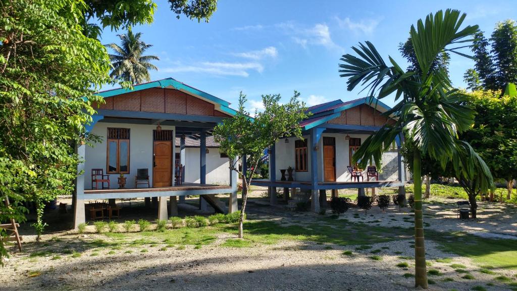 LagudriNew Raya - Nias Beach Bungalows的前面有棕榈树的房子
