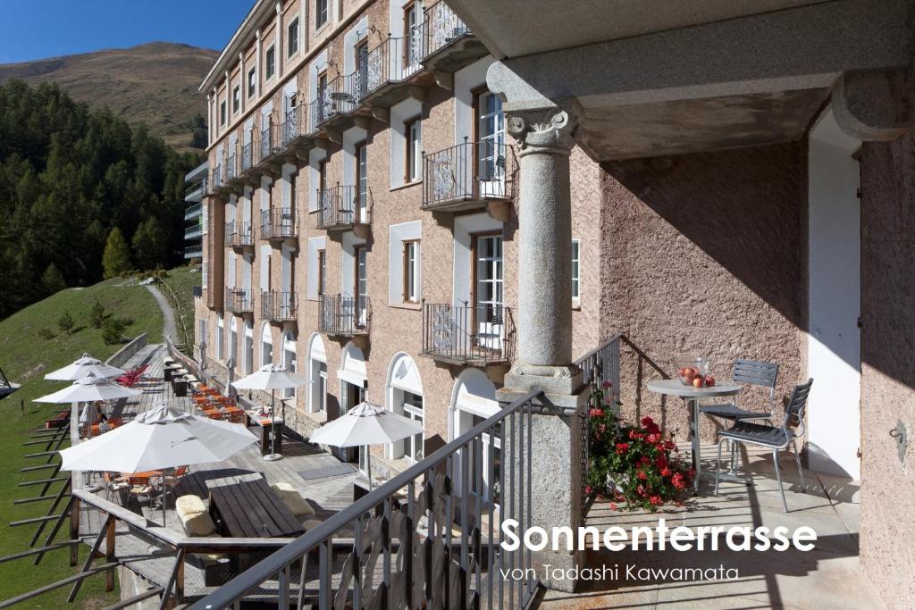 楚奥茨卡斯特尔酒店的带有桌子和遮阳伞的建筑阳台