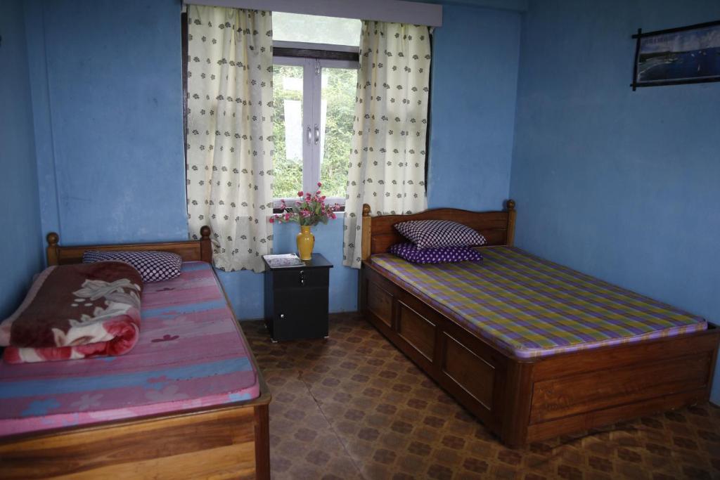 拉瓦格拉Vamoose Borong Polok Village Homestay的一间卧室设有两张床和窗户。