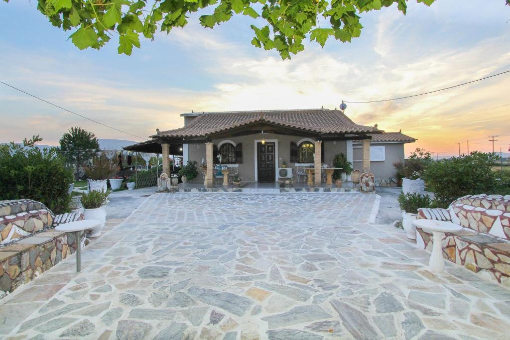 卡拉马孔Kouros resort的一座房子,在一座建筑前设有石头庭院
