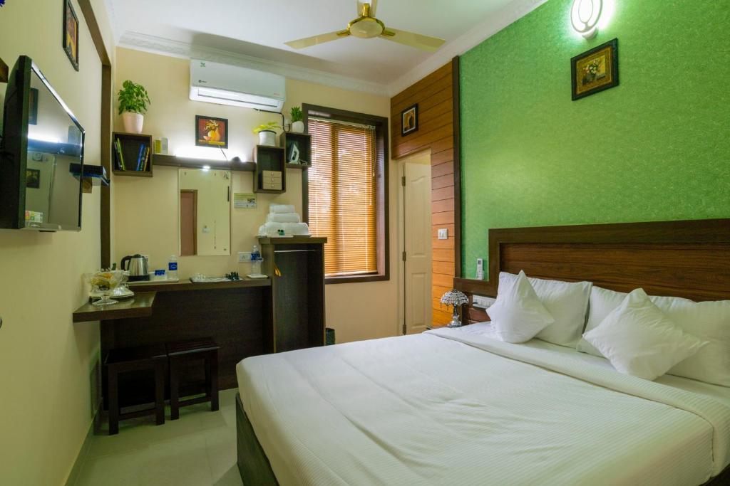 尼杜巴塞莱Blue Bell Cochin Airport Hotel的一间卧室配有一张带绿色墙壁的床