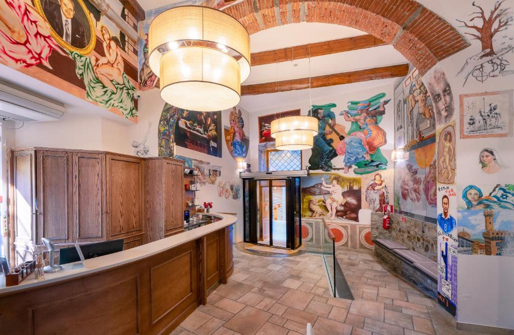 佛罗伦萨亚奇罗希酒店的大型客房的墙壁上装饰有绘画作品