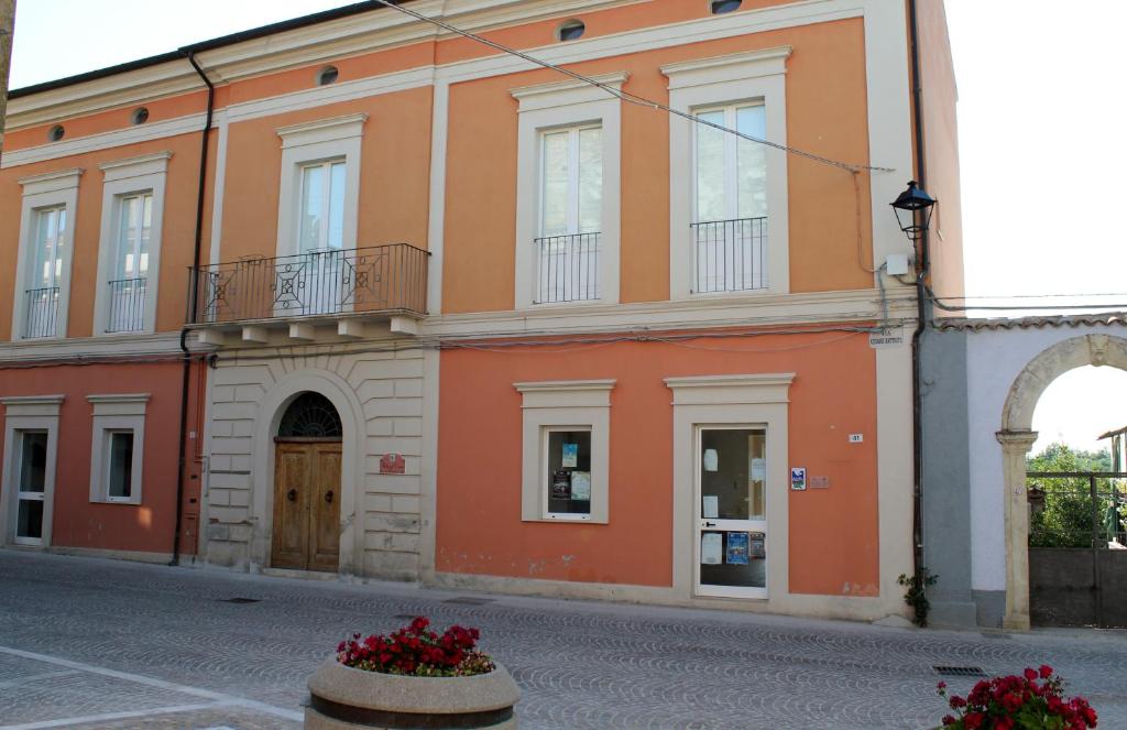 罗卡圣焦万尼Palazzo Croce的一座橙色的建筑,前面有鲜花