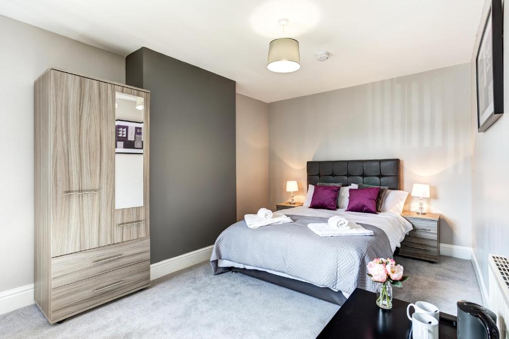克鲁Clen Holme House的一间卧室配有一张带紫色枕头的大床
