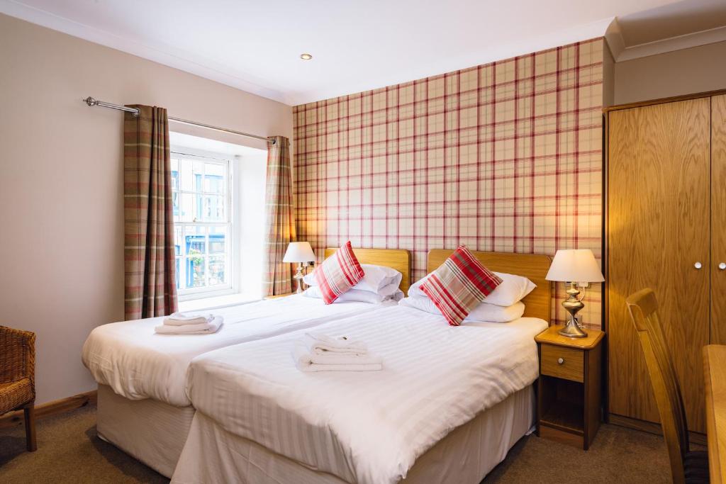 赖厄德爱兰酒店的一间卧室设有两张床和窗户。