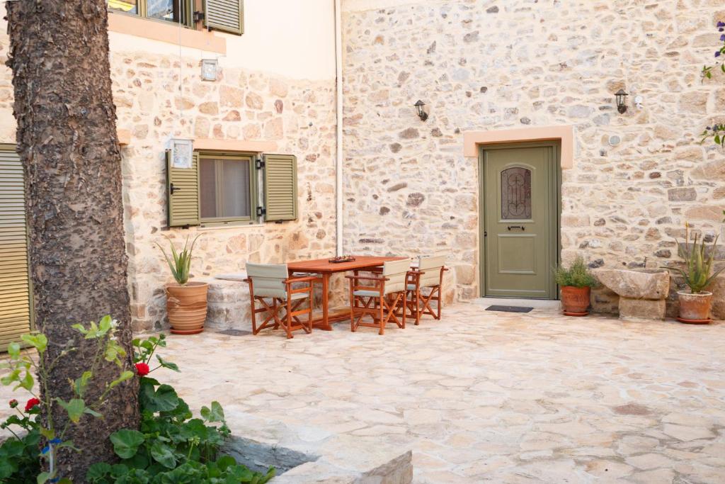 泰帕奇Traditional Villa Priotissa的一个带桌椅的庭院和一座建筑