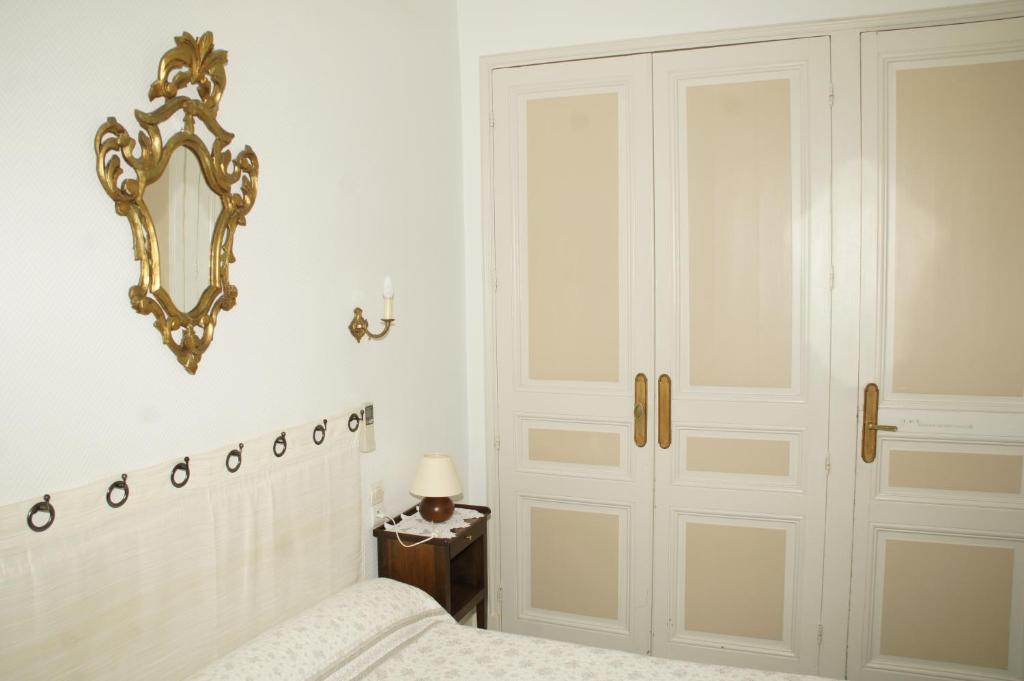 卡尔卡松蒙特古酒店的卧室配有一张床,墙上设有镜子