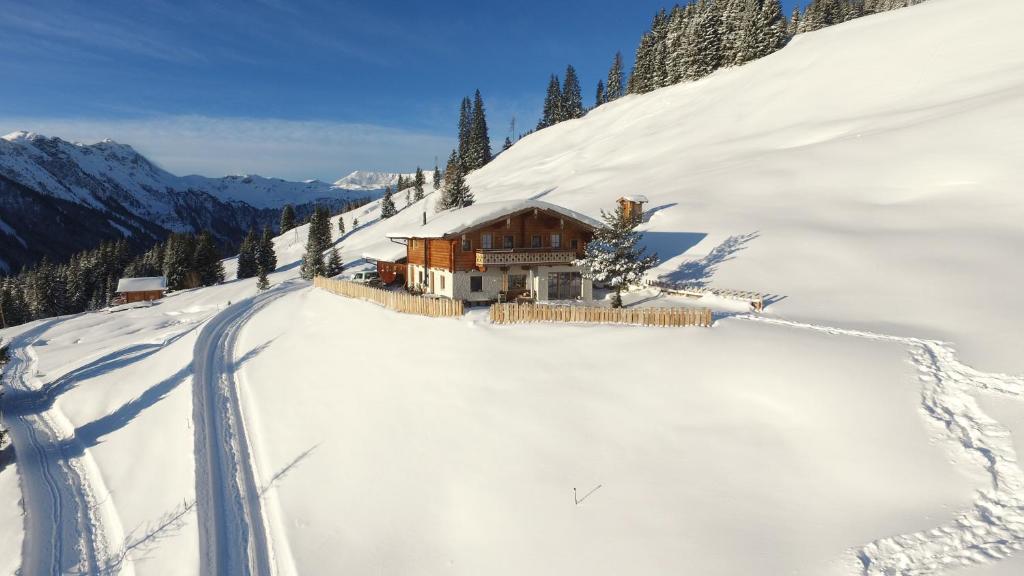 萨尔巴赫Wallegg Lodge - Alpine Premium Chalet - Ski In-Ski Out的山里有一条路的雪地房子