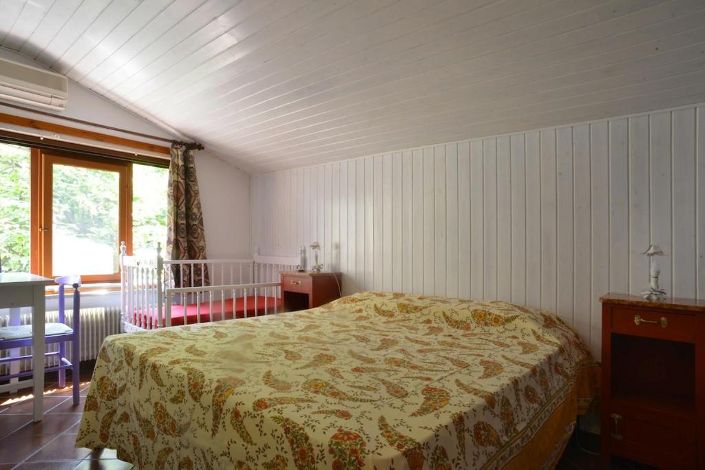 格拉多Casetta Liberty的一间卧室配有一张床、一张桌子和一个窗户。