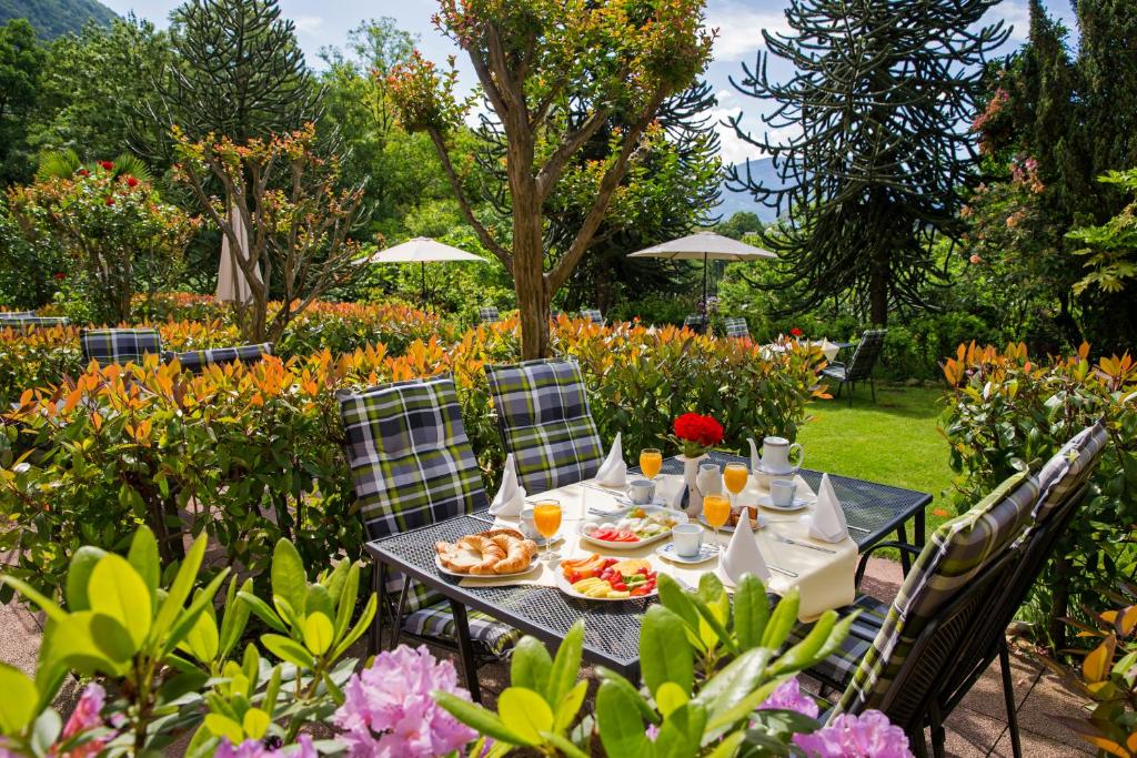 台格纳Hotel Al Fiume的花卉园里的桌子,上面放着食物和饮料