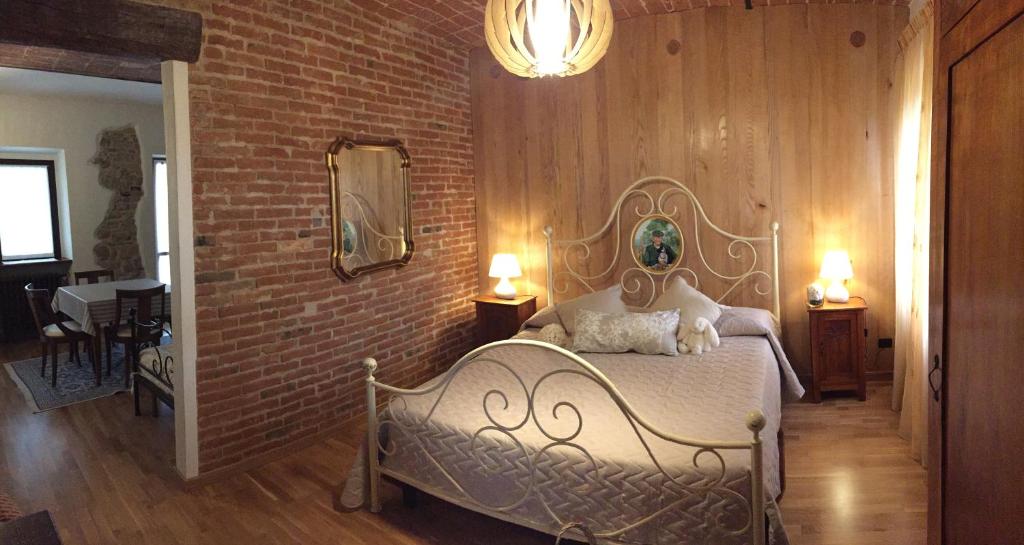 迪亚诺达尔巴Cascina Maina的一间卧室设有一张床和砖墙