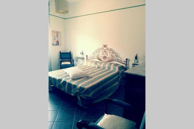 因佩里亚La bomboniera的一间卧室配有一张床和一把椅子