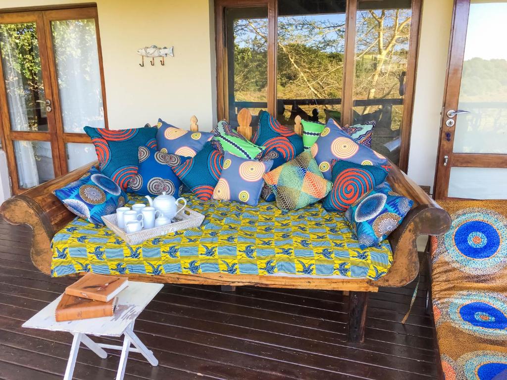 Ponta MalanganeNkumbe Bush Retreat Family Home的门廊上的沙发,配有色彩缤纷的枕头