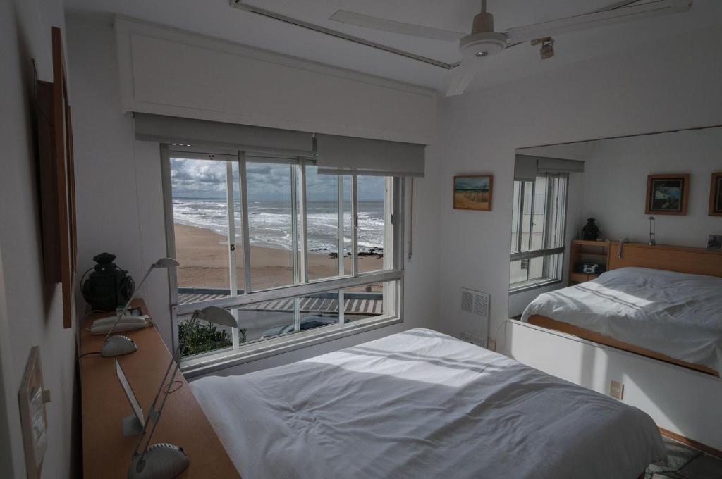 埃斯特角城Departamento Vista al Mar的卧室设有窗户,享有海滩美景