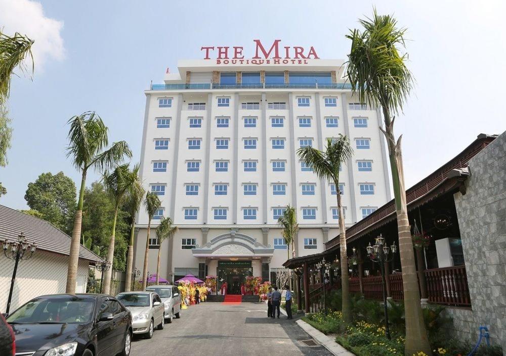土龙木市米拉精品酒店的一座白色的大建筑,上面有标志