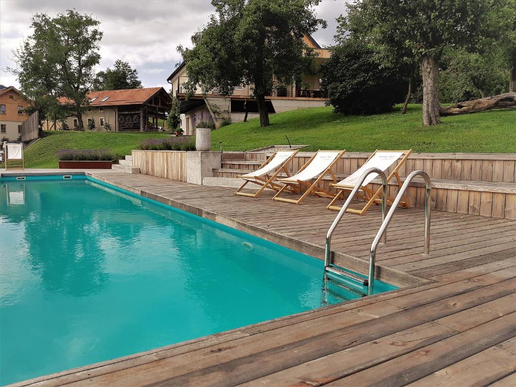 PolzelaLavender Hill, Eko Resort & Wellness的一个带躺椅的游泳池,毗邻一个木甲板