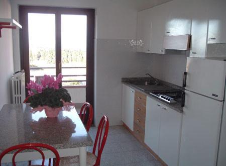 布里亚蒂科欧亚希住宅酒店的厨房配有桌椅和冰箱。