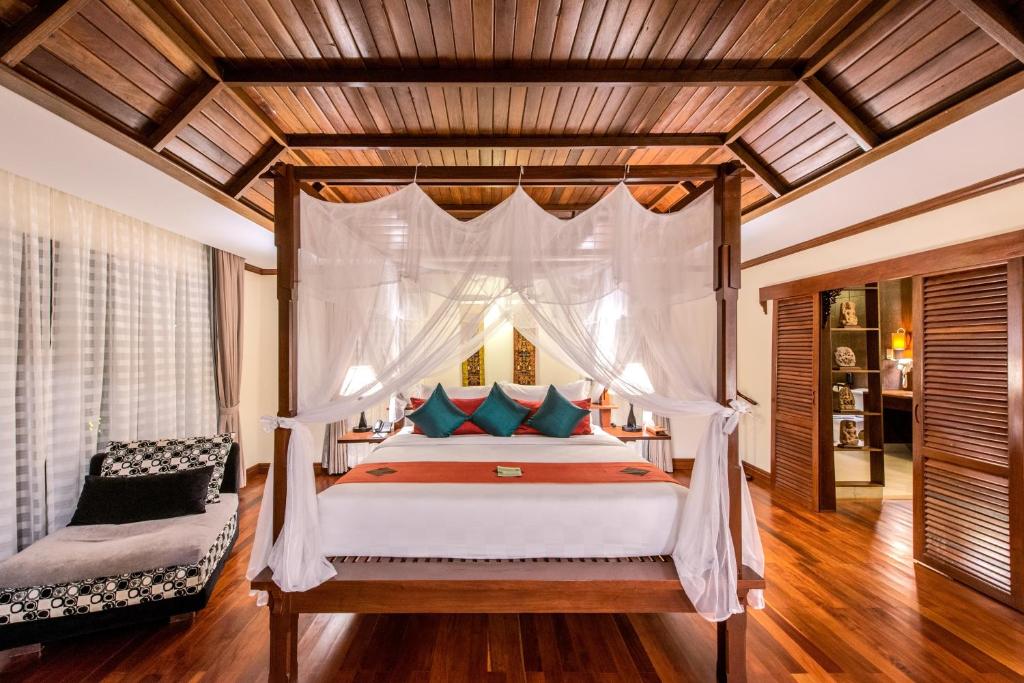 暹粒暹粒宫殿别墅酒店的一间卧室配有一张带天蓬的床