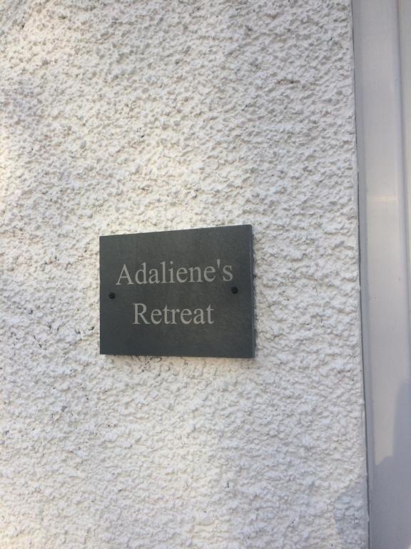 波特里Adalienes Retreat的白色墙边的标志