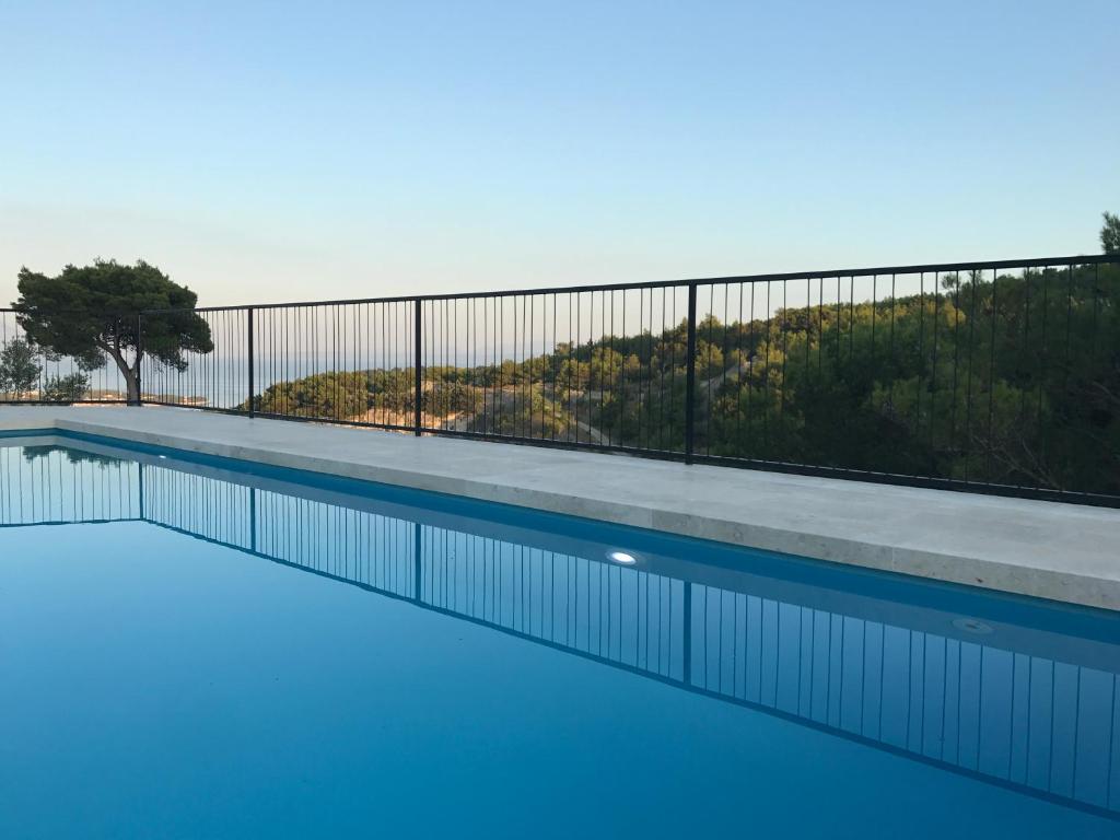 塞尔察Villa Pietra的蓝色海水游泳池和围栏