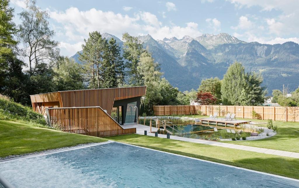 布鲁登茨Val Blu Sport | Hotel | SPA的一座房子,后面设有游泳池和山脉